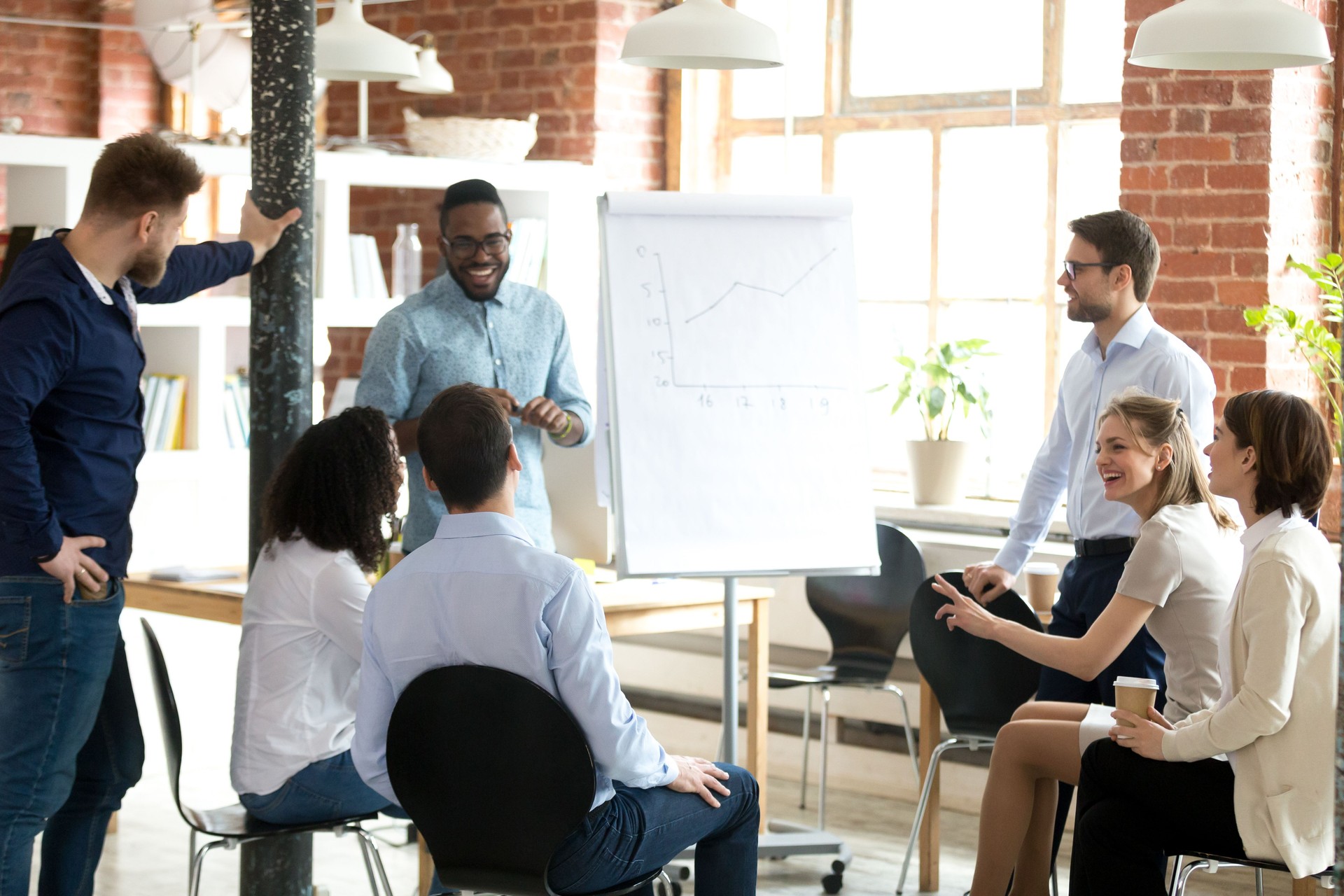 Excité entraîneur noir marque flipchart présentation pour les employés